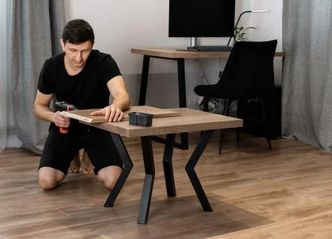 Man assembling a wooden coffee table Foto stock