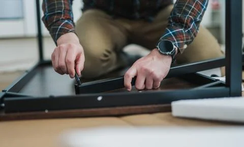 Man assembling writing table, flat-pack furniture Stock Photos
