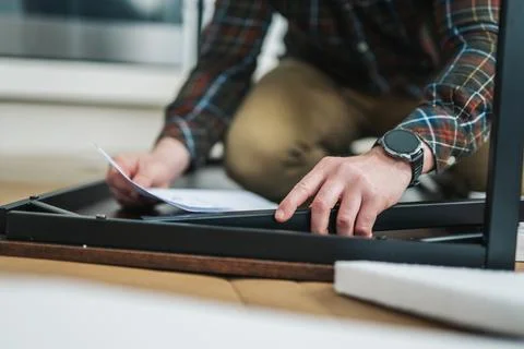 Man assembling writing table, flat-pack furniture Stock Photos