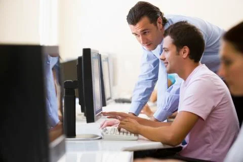 Man assisting other man in computer room Stock Photos