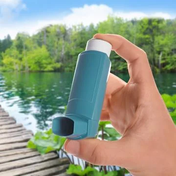 Man with asthma inhaler near lake, closeup. Emergency first aid during outd.. Stock Photos