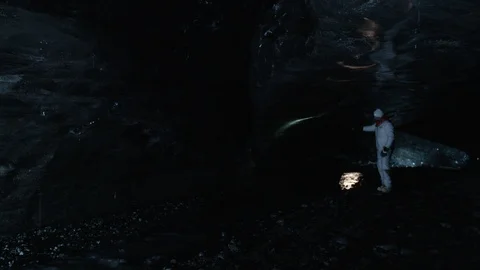 Man in astronaut suit exploring an ice cave, Iceland Video stock 104236999