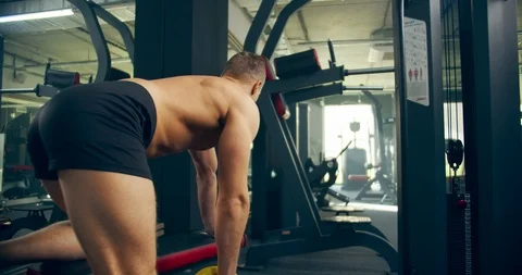 Man Athlete bent-over dumpbell rows exercise in gym hard working Video stock 126937779