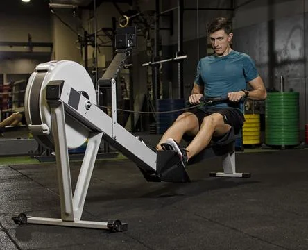 Man athlete doing exercise with a machine Stock Photos