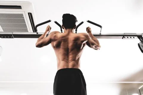 Man Athlete Doing Pull Ups - Chin-Ups In The Gym 库存照片