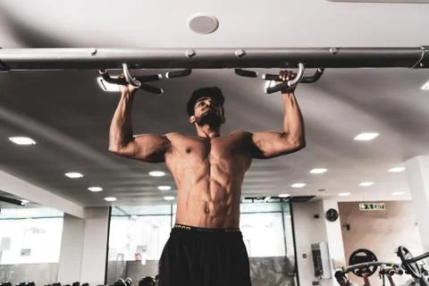 Man Athlete Doing Pull Ups - Chin-Ups In The Gym 库存照片