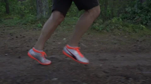 Man athlete runner jogging along forest path in summer day Stock Footage 228934681