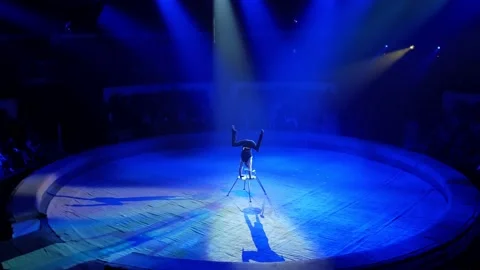 A man of athletic build performs complex gymnastic exercises in a circus Stock Footage 149177844