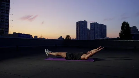 A man with an athletic physique performs an exercise for abs on a mat. Stock Footage 256913249