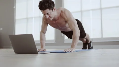 Man athletic trainer doing push up in gym And live teaching via laptop Or video Vidéo 149001059