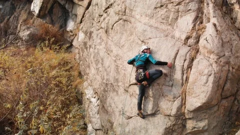 Man athlette climbing on the high rock Stock Footage 164537019
