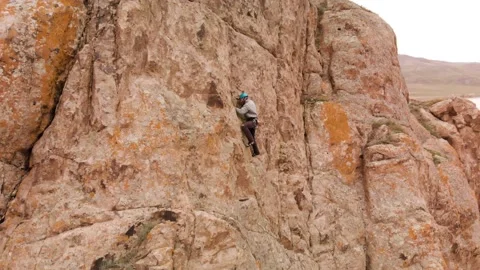 Man athlette climbing on the high rock Stock Footage 174094838