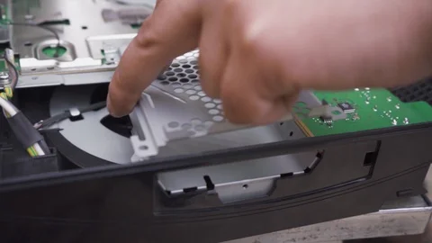 Man attaches the cooling system of the electronic board of the game console Stock Footage 108664591