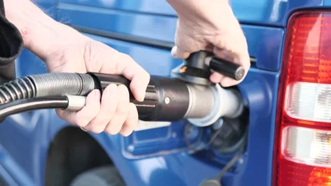 A man attaches a gas nozzle to a compressed natural gas CNG powered car Stock Footage 234445909
