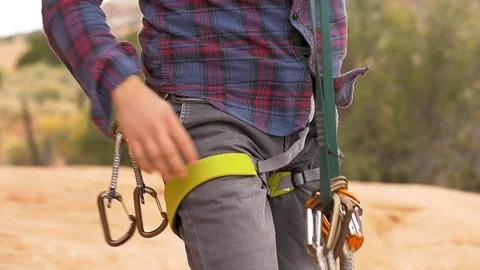 Man Attaches Multiple Locking Carabiners On His Belt Video stock 78992230