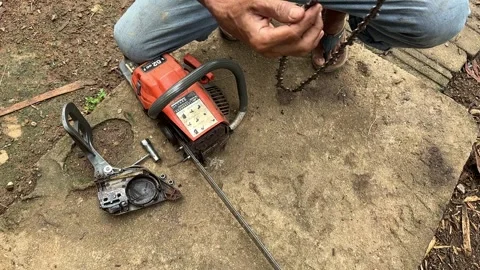 Man attaching chainsaw chain after repair Stock Footage 326284425