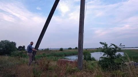 Man attaching hammock straps to concrete poles while camping outdoors Stock-Footage 339591766