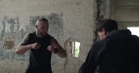 Man attacks on tattooed athlete during freestyle wrestling in abandoned building Stock Footage 131390594