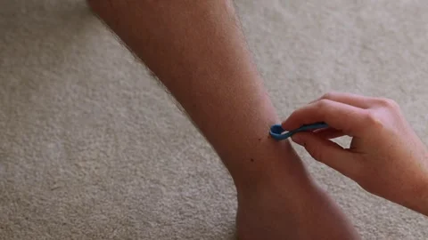 Man attempting to remove stubborn ticks lodges into a persons leg Stock Footage 310767586