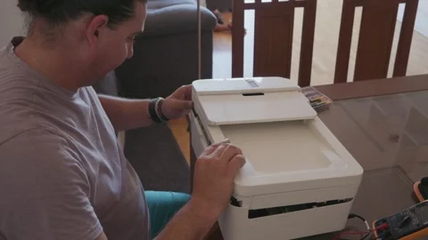 Man attempting to repair a broken printer Stock Footage 336950434