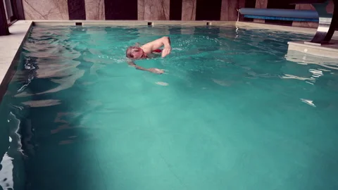 A man is attempting to swim in the pool. Stock Footage 311246136