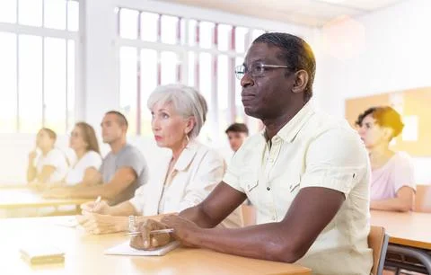 Man attending foreign language course in classroom Stock Photos