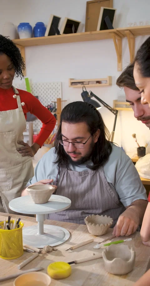 Man attending pottery class explains the process of making clay shapes to f.. Stock Footage 345207459