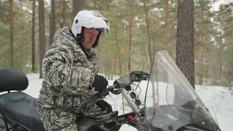 Man on ATV exploring cold winter wilderness with caution. Adventure amidst snowy Stock Footage 332055326