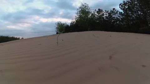 A man on an ATV flies out of a sandy hillock, a guy rides an ATV on the sand Stock Footage 202101748