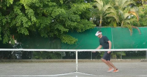 Man in augmented virtual reality headset plays tennis outdoor. Stock Footage 269976423
