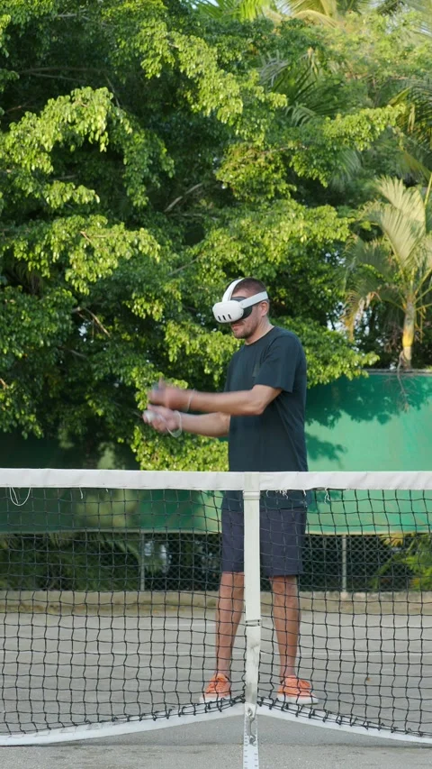 Man in augmented virtual reality headset plays tennis outdoor. Stock Footage 269976735
