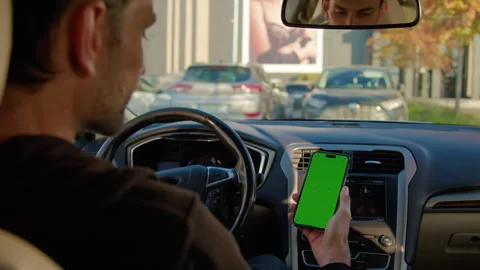Man in auto holds smartphone scrolling car sharing app Stock Footage 300582298