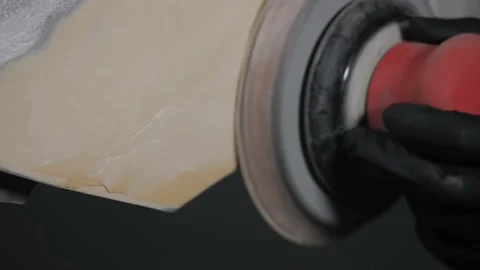 A man auto mechanic uses a grinder to grind a putty on a damaged car body part.  Video stock 202170006