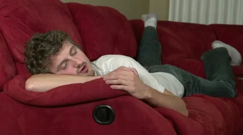 Man awakes from nap on couch Stock Footage 12160660