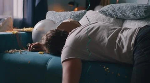 Man awaking in trashed room after party Foto stock
