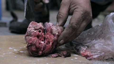 Man with an ax chopping a piece of dead animal Stock Footage 110869828