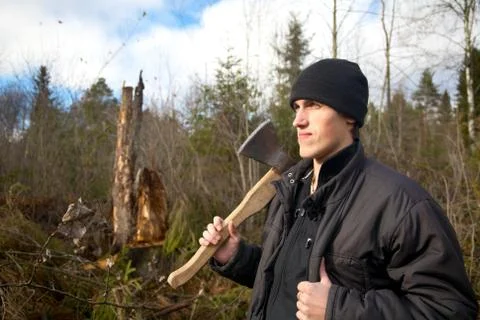 Man with an axe looks at the tumbled down wood Stock Photos