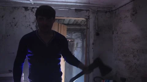 A man with an axe standing in a dark room and breathing deeply. copy space Stock-Footage 137970107