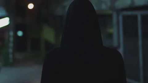 Man with Back Against Camera with Black Hood in a Deserted Neighborhood 動画素材 150087950