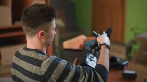 Man with back to camera adjusting video equipment in home studio Vídeo Stock 317585834