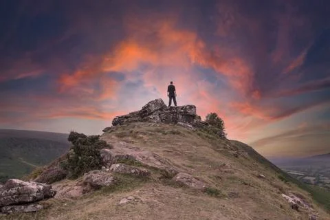 A man, back to camera standing on top of a mountain Stock Photos