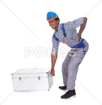 Man with back pain lifting metal box Stock Photos