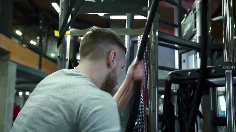 Man with back pulls rope in a cross-training session in the gym. Stock Footage 89036278