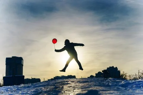 Man from the back with a red balloon in hand against the blue sky on frosty day Stock Photos