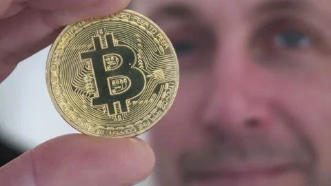 Man in Background Holding Bitcoin 動画素材 154244786