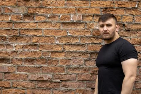 Man on the background of a red brick wall. Stock Photos