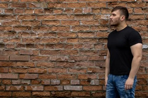 Man on the background of a red brick wall. Stock Photos