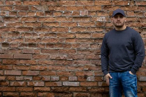Man on the background of a red brick wall. Stock Photos