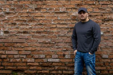 Man on the background of a red brick wall. Stock Photos