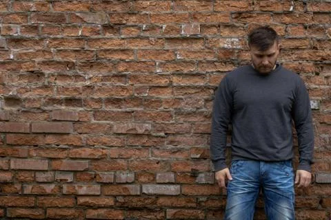 Man on the background of a red brick wall. Stock Photos